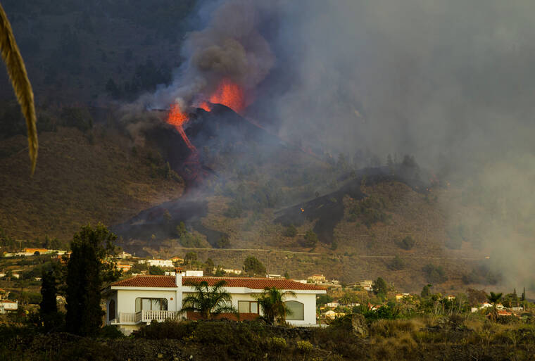 Lava flows from an eruption of a volcano at the island of La Palma in the Canaries, Spain, Sunday, Sept. 19, 2021. A volcano on Spain's Atlantic Ocean island of La Palma erupted Sunday after a weeklong buildup of seismic activity, prompting authorities to evacuate thousands as lava flows destroyed isolated houses and threatened to reach the coast. New eruptions continued into the night. (AP Photo/Jonathan Rodriguez)