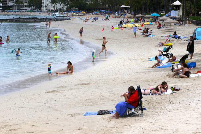 ASSOCIATED PRESS
                                People sat on Waikiki Beach, Aug. 24, in Honolulu. Hawaii officials are facing pressure to increase COVID-19 testing for travelers.