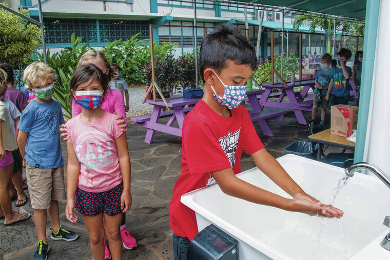 CRAIG T. KOJIMA / CKOJIMA@STARADVERTISER.COM 
                                Students lined up to wash their hands Friday after returning from the playground at Ka‘ohao Charter School in Lanikai.