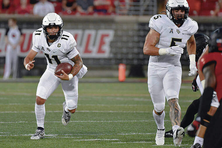 ASSOCIATED PRESS
                                Central Florida quarterback Dillon Gabriel (11) runs through an opening in the Louisville defensive line during the first half of an NCAA college football game in Louisville, Ky.