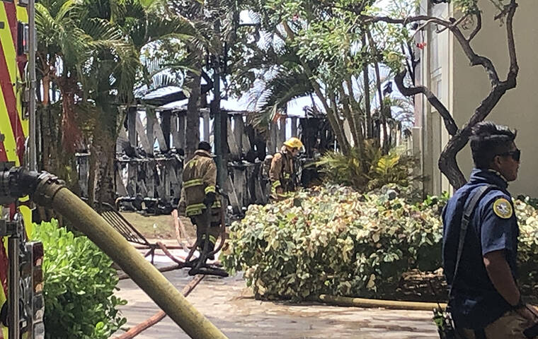 COURTESY JACQUELIN KRONICK
                                Firefighters work after putting out a fire at the surfboard racks near the HPD Waikiki substation today.