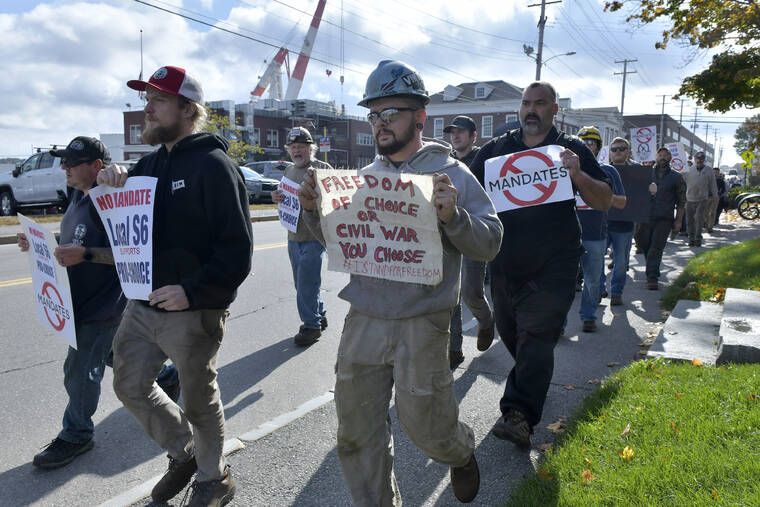 ASSOCIATED PRESS / OCT. 22
                                Justin Paetow, center, a tin shop worker at Bath Iron Works, takes part in a demonstration against COVID-19 vaccine mandate outside the shipyard in Bath, Maine. Some American workers are making the painful decision to quit their jobs and abandon cherished careers in defiance of what they consider intrusive vaccine mandates requiring all businesses with 100 or more workers be fully vaccinated against COVID-19.