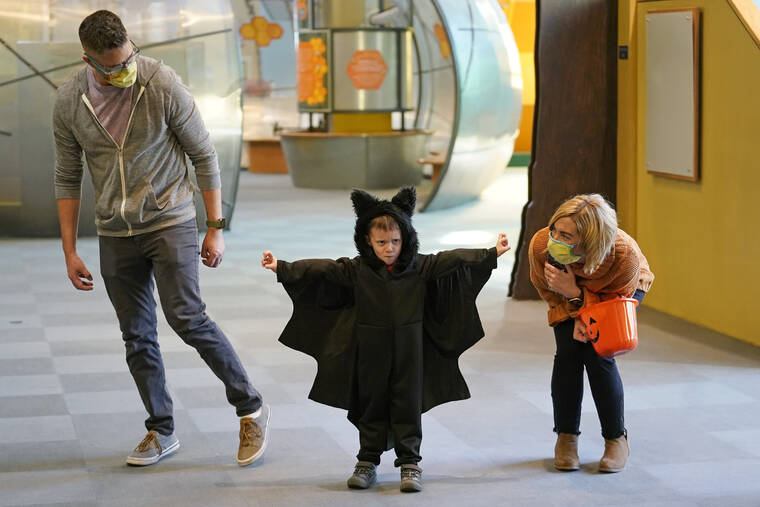 ASSOCIATED PRESS
                                Grayson Martin, 3, posed in his costume as his parents Rachelle and Patrick Martin, looked on, during a visit to Discovery Gateway Children’s Museum, Thursday, in Salt Lake City. Coronavirus cases in the U.S. are on the decline, and trick-or-treaters can feel safer collecting candy.