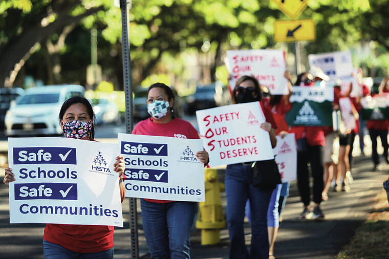 JAMM AQUINO / JAQUINO@STARADVERTISER.COM
                                Sheila Leong, left, joined other members of the Hawaii State Teachers Association as they held signs and picketed along Punchbowl Street on Wednesday in Honolulu.
