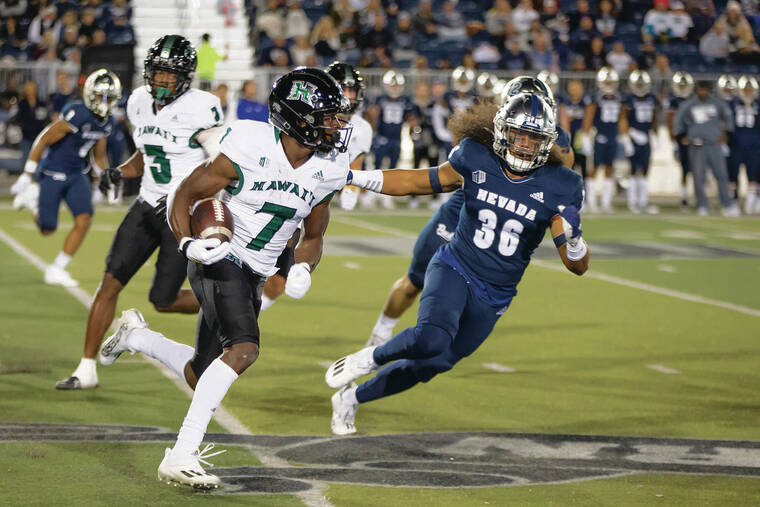 ASSOCIATED PRESS
                                Hawaii’s Calvin Turner Jr. looked for running room while being chased by Nevada linebacker Naki Mateialona during the first half Saturday in Reno, Nev.