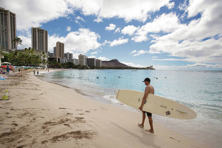CINDY ELLEN RUSSELL / CRUSSELL@STARADVERTISER.COM
                                September gains in visitor arrivals from key U.S. markets were not enough to offset continued flatlining international travel to Hawaii. Above, a surfer carried his board Wednesday along the shores of Waikiki while activity was light overall in the area.