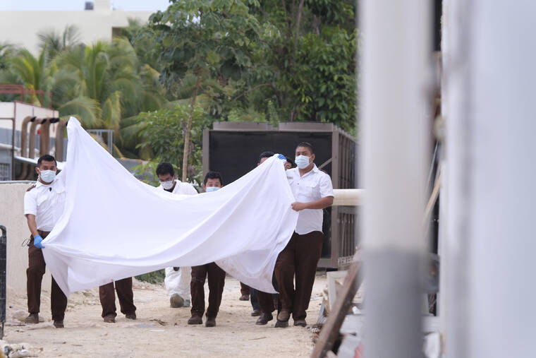 ASSOCIATED PRESS / NOV. 4
                                Police hold a bed sheet in an attempt to block onlookers after an armed confrontation close to a hotel near Puerto Morelos, Mexico. Two suspected drug dealers were killed after gunmen from competing gangs staged a dramatic shootout near upscale hotels that sent foreign tourists scrambling for cover.