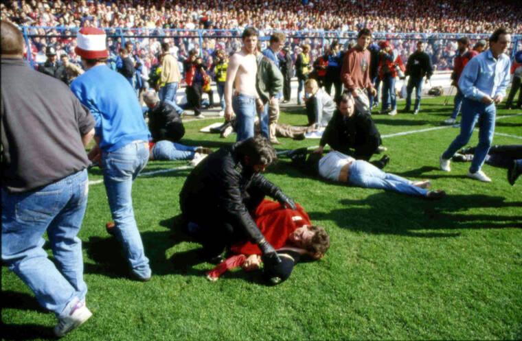 ASSOCIATED PRESS / APRIL 15, 1989
                                Police, stewards and supporters tend and care for wounded supporters on the field at Hillsborough Stadium, in Sheffield, England. The 96 Liverpool soccer fans who died in the Hillsborough Stadium disaster were “unlawfully killed” because of errors by the police, a jury concluded Tuesday, April 26, 2016.