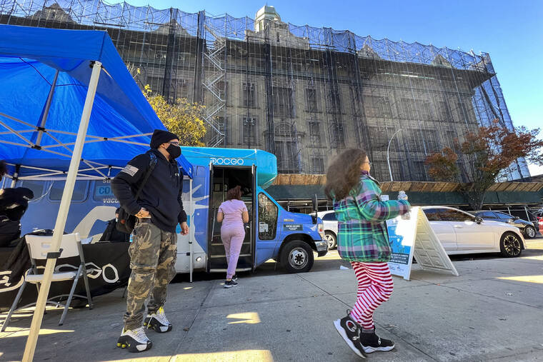 ASSOCIATED PRESS
                                A girl walks outside of a mobile vaccine unit after getting the first dose of her COVID-19 vaccine outside P.S. 277 on Friday in the Bronx borough of New York.