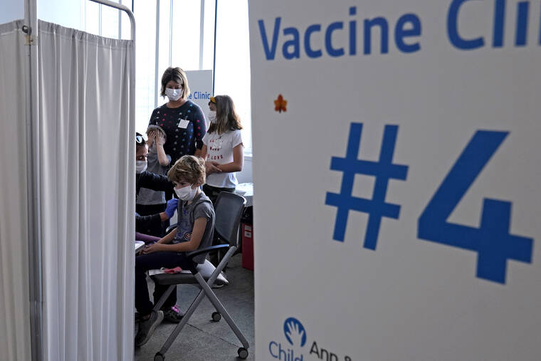 ASSOCIATED PRESS
                                Graham Roark, 8, received the Pfizer COVID-19 vaccine for children 5 to 11 years from Lurie Children’s hospital registered nurse Virginia Scheffler at the hospital, Nov. 5, in Chicago. First shots are averaging about 300,000 per day.