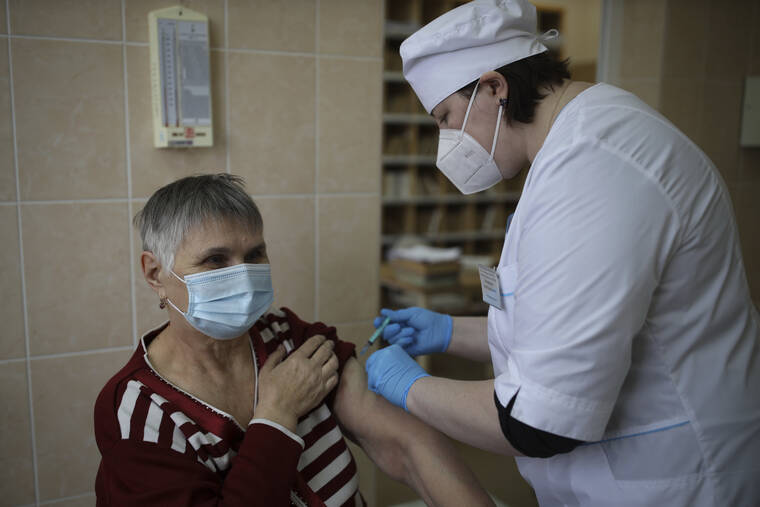 ASSOCIATED PRESS
                                A medical worker administers a shot of Russia’s coronavirus vaccine to an elderly woman in Korenovsk, Krasnodar region, south of Moscow, today. Russia is reporting a new daily high number of COVID-19 deaths, while the the total number of infections during the pandemic in the country has topped 9 million.