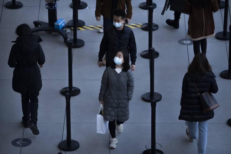 ASSOCIATED PRESS
                                People wearing face masks to protect against COVID-19 wait in line to enter a store at an outdoor shopping center in Beijing, Saturday.