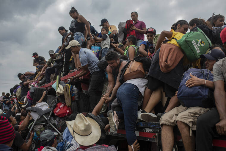 ASSOCIATED PRESS
                                Migrants help fellow migrants onto the bed of a trailer in Jesus Carranza, in the Mexican state of Veracruz. A group of mainly Central American migrants are attempting to reach the U.S.-Mexico border.