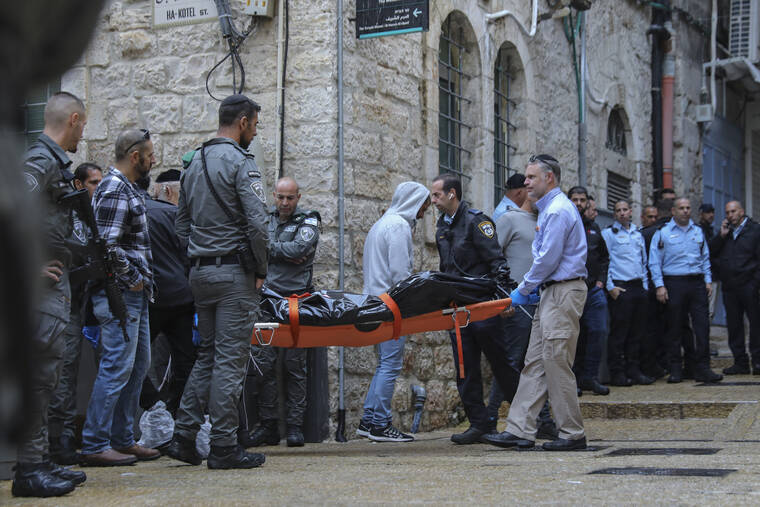 ASSOCIATED PRESS
                                Israeli security personnel and members of Zaka Rescue and Recovery team carry the body of a Palestinian man who was fatally shot by Israeli police after he killed one Israeli and wounded four others in a shooting attack in Jerusalem’s Old City today.