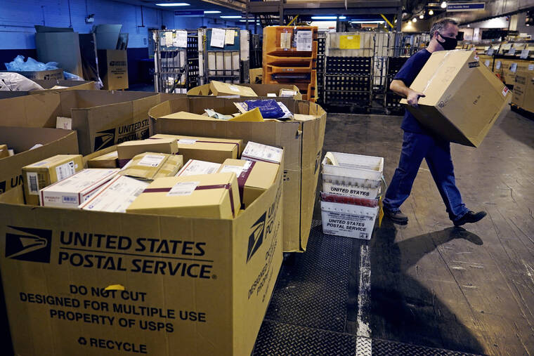 ASSOCIATED PRESS / NOV. 18
                                A worker carries a large parcel at the United States Postal Service sorting and processing facility in Boston. Last year’s holiday season was far from the most wonderful time of the year for the beleaguered U.S. Postal Service. Shippers are now gearing up for another holiday crush.