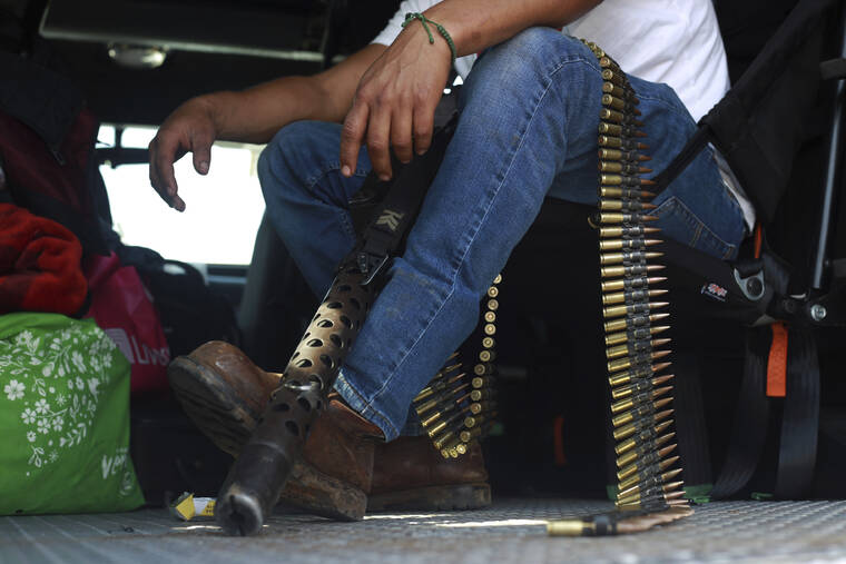 ASSOCIATED PRESS
                                A member of the so-called self-defense group known as United Towns or Pueblos Unidos, sits with his ammunition during a rally in Nuevo Urecho, in the Mexican western state of Michoacan. Extortion of avocado growers in western Mexico has gotten so bad that 500 vigilantes from the “self-defense” group gathered Saturday and pledged to aid police.