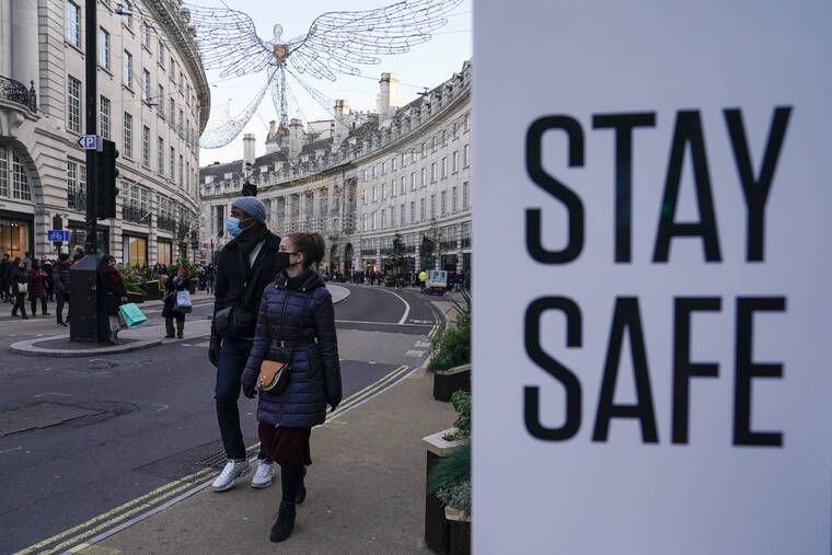 ASSOCIATED PRESS
                                People wear face masks as they walk in London today.