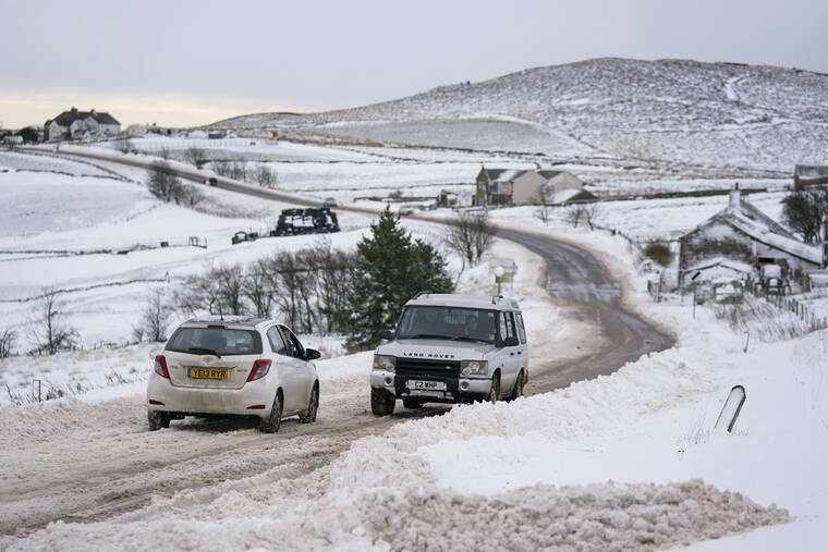 ASSOCIATED PRESS
                                Vehicles travel tentatively on the snow-covered A53 close to Buxton in Derbyshire, amid freezing conditions in the aftermath of Storm Arwen, England, today.