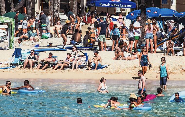 CRAIG T. KOJIMA / CKOJIMA@STARADVERTISER.COM
                                Sunbathers and swimmers made the most of the morning sun at Waikiki Beach on Oct. 15.