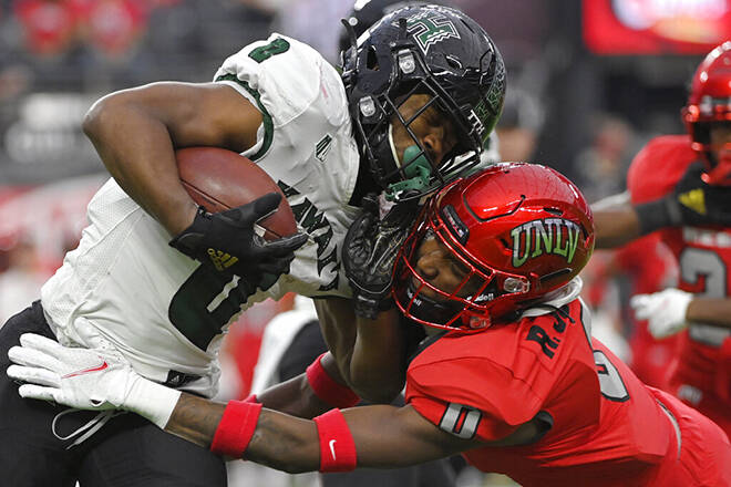 ASSOCIATED PRESS
                                UNLV defensive back Ricky Johnson, right, attempts to tackle Hawaii running back Dae Dae Hunter during the first half of an NCAA college football game today in Las Vegas. UNLV won, 27-13.