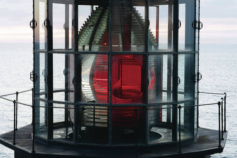 NEW YORK TIMES
                                The Cape Meares ­Lighthouse, with cherry-­colored panels on its Fresnel lens, at Cape Meares State Park.