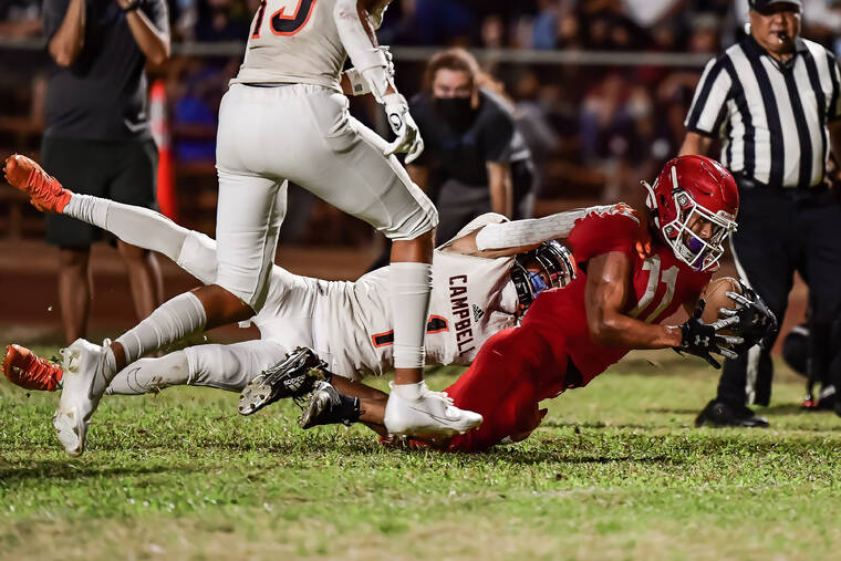 STEVEN ERLER / SPECIAL TO THE STAR-ADVERTISER
                                Kahuku running back Kainoa Carvalho dove towards the endzone while being tackled by Campbell utility player Dominick Espinda.
