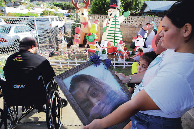 JAMM AQUINO / JAQUINO@STARADVERTISER.COM
                                Erin French, 16, and brother Matthias, 6, look at a photo of their mother, Melissa Santos, Tuesday as their father, Roy, sits in his wheelchair in Waianae.