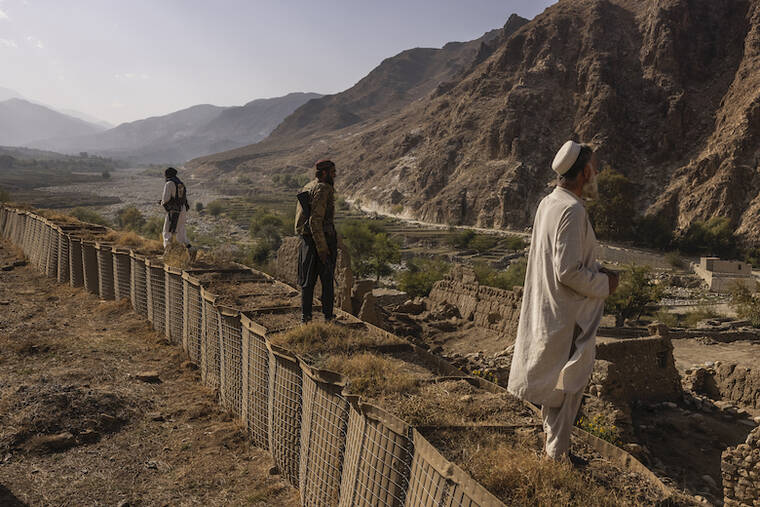 VICTOR J. BLUE/THE NEW YORK TIMES / OCT. 21
                                Two Taliban fighters — Nasrat, 21, left, Khadim, 22, center — and a local resident, Musafir Shinwari, look over the Mohmand Valley from an abandoned U.S. Special Forces base in the Achin District of Afghanistan’s Nangarhar provincw. The Taliban takeover was supposed to bring an end to war, the new government promised. But a growing insurgency is upending security and raising alarms for the international community.