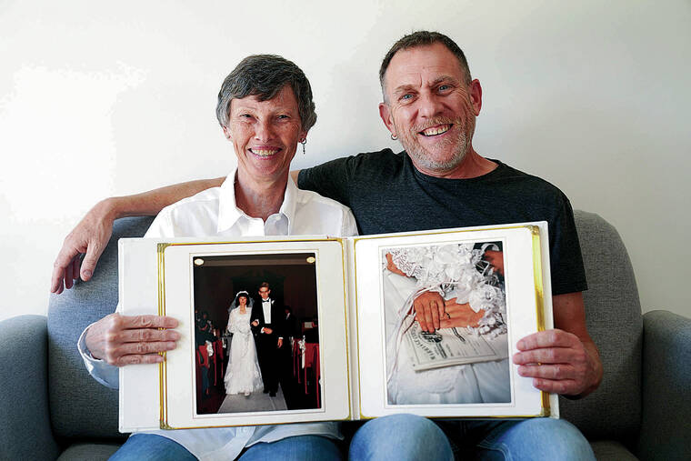 ASSOCIATED PRESS
                                Cyndi and Brad Marler sit for a portrait with their 1989 wedding album at Cyndi’s apartment in Chicago. A few years after they married, each told the other they are gay and for more than three decades they kept their secret from everyone else, including their two children.