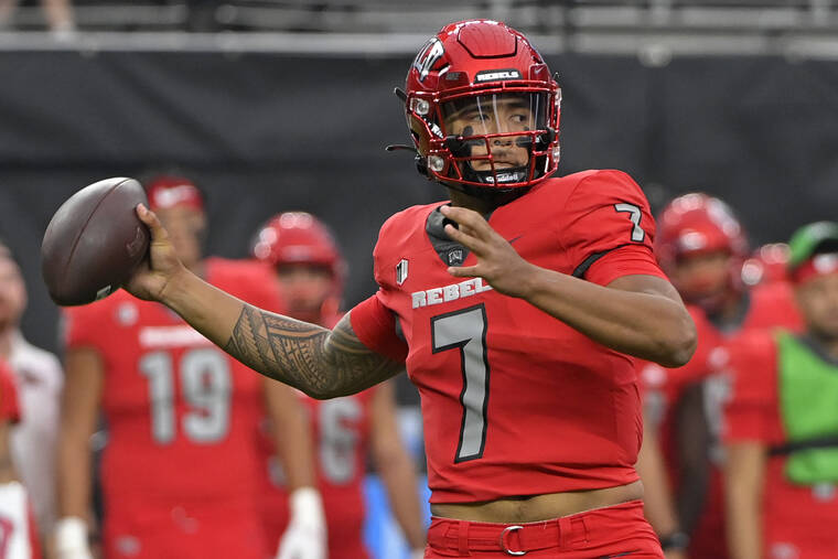 ASSOCIATED PRESS UNLV quarterback Cameron Friel, a Kailua High alumnus, looks to pass Hawaii in the first half of an NCAA college football game on Saturday in Las Vegas.