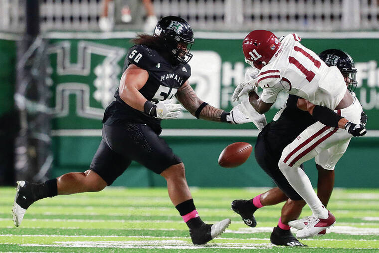 GEORGE F. LEE / OCT. 23
                                UH’s Justus Tavai, left, gave chase as another Warriors player knocked the ball free from New Mexico State receiver Andre Bodison on Oct. 23 at the Ching Complex.