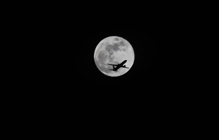 JAMM AQUINO /JAQUINO@STARADVERTISER.COM An Alaska Airlines 737-Max aircraft passes in front of the full moon on Thursday in Honolulu.