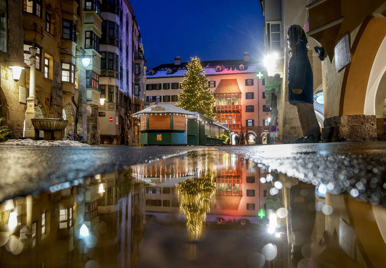 ASSOCIATED PRESS
                                The Christmas tree of the closed Christmas market was reflected in a puddle in Innsbruck, Austria, Monday. As countries shut their doors to foreign tourists or reimpose restrictions because of the new omicron variant of the coronavirus, tourism that was just finding its footing again could face another major pandemic slowdown amid the uncertainty about the new strain.