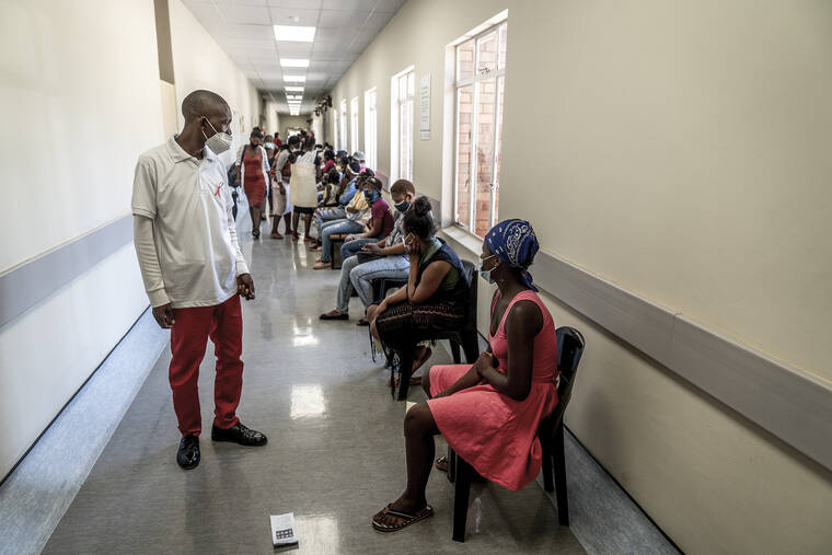 ASSOCIATED PRESS
                                A hospital worker ensures people practice social distancing as they wait in line to get vaccinated against COVID-19 at the Lenasia South Hospital, near Johannesburg, South Africa, today.