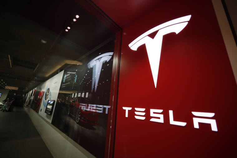ASSOCIATED PRESS / 2019
                                A sign bearing the company logo outside a Tesla store in Cherry Creek Mall in Denver. Tesla says it has officially moved its corporate headquarters from Silicon Valley to a large factory under construction outside of Austin, Texas. The company made the announcement in a filing with U.S. securities regulators.