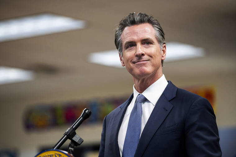 ANDREW KUHN/THE MERCED SUN-STAR VIA AP
                                Governor Gavin Newsom announces the confirmation of California’s first case of the omicron variant of COVID-19 during a visit to a vaccination clinic at Frank Sparkes Elementary School in Winton, Calif.