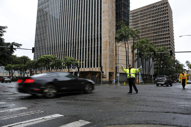ASSOCIATED PRESS
                                A police officer directed traffic during a power outage in downtown Honolulu, Tuesday, after a severe winter storm swept the islands.