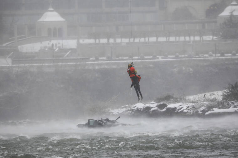 DEREK GEE/BUFFALO NEWS VIA AP
                                A U.S. Coast Guard rescue diver removes a passenger from a vehicle in the water at the brink of Niagara Falls, N.Y.