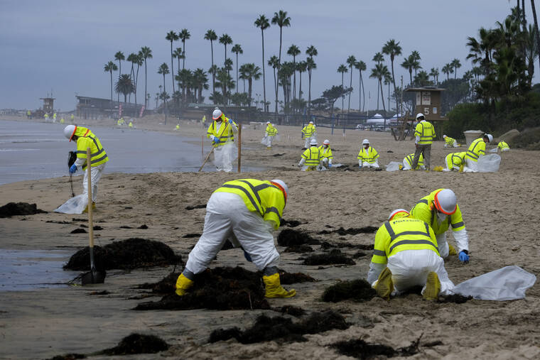 RINGO H.W. CHIU / AP
                                Workers in protective suits clean the contaminated beach in Corona Del Mar after an oil spill off the Southern California coast in October.