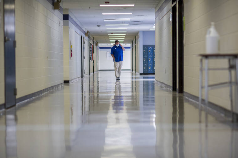 ASSOCIATED PRESS
                                A middle school principal walked the empty halls of his school as he spoke with one of his teachers to get an update on her COVID-19 symptoms, Aug., 20, in Wrightsville, Ga. U.S. health officials, today, cut isolation restrictions for Americans who catch the coronavirus from 10 to five days, and also shortened the time that close contacts need to quarantine.