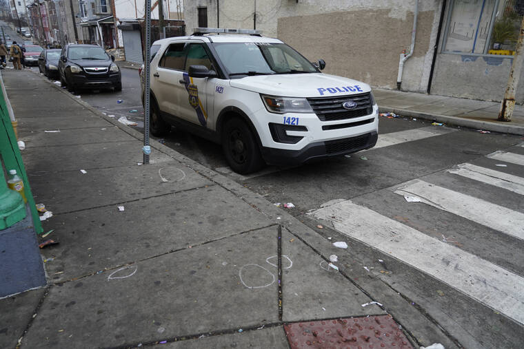 ASSOCIATED PRESS
                                A Philadelphia police vehicle is seen parked next to chalk marks that identified spent bullet casings in Philadelphia. Two gunmen fired more than 65 rounds on a Philadelphia street last night, sending nighttime pedestrians on a busy block teeming with markets and restaurants scrambling for cover and injuring six people, at least one of them critically, police said Friday.