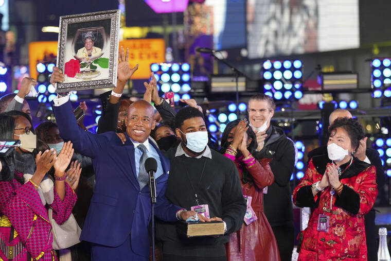INVISION / AP
                                Eric Adams holds up a framed image at his swearing-in as New York mayor at the Times Square New Year’s Eve celebration early today.