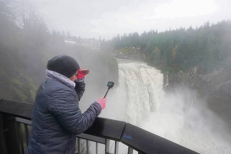 Associated Press / Nov. 12
                                A visitor to Snoqualmie Falls in Snoqualmie, Wash., captures the gushing water on video as storms caused by the Pineapple Express atmospheric river hit Washington and Oregon.