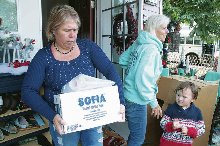 CRAIG T. KOJIMA / CKOJIMA@STARADVERTISER.COM
                                Kris Buchanan, whose husband is in the Navy and whose family has been experiencing health problems, received some water on Saturday. Also pictured is her son, Micah, and mother, Mechele Ralph.