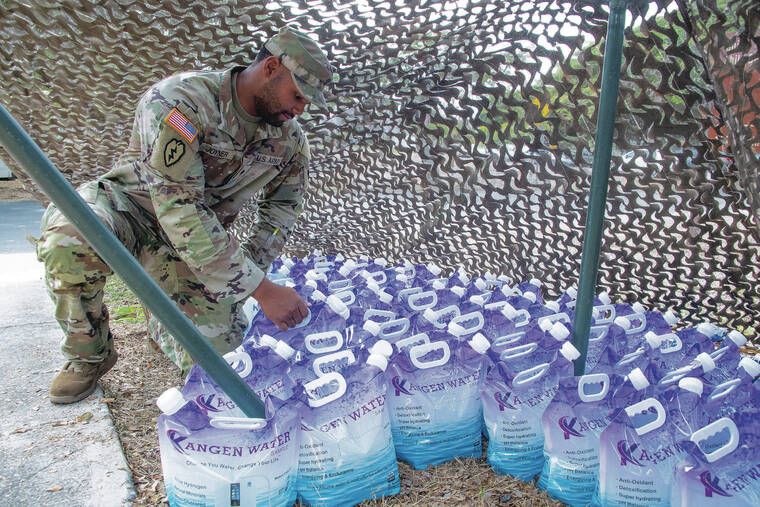 CRAIG T. KOJIMA / CKOJIMA@STARADVERTISER.COM
                                Army Spc. Jashawn Joyner grabbed ready-to-go containers of water.