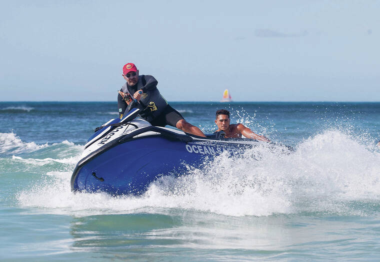 CINDY ELLEN RUSSELL CRUSSELL@STARADVERTISER.COM
                                Veteran lifeguard and certified jet ski operator Ramses “Kucho” Rosa with lifeguard Kekoa Kekumano, who is also an actor in his free time, at Kaimana Beach on Thursday.