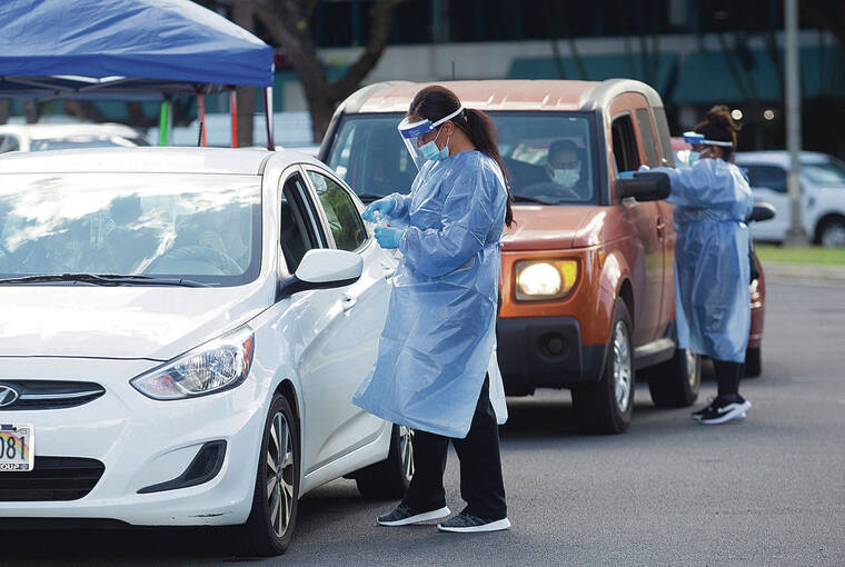 CINDY ELLEN RUSSELL / CRUSSELL@STARADVERTISER.COM 
                                Health care workers administered COVID-19 tests at the drive-thru testing site Monday at Neal Blaisdell Center.