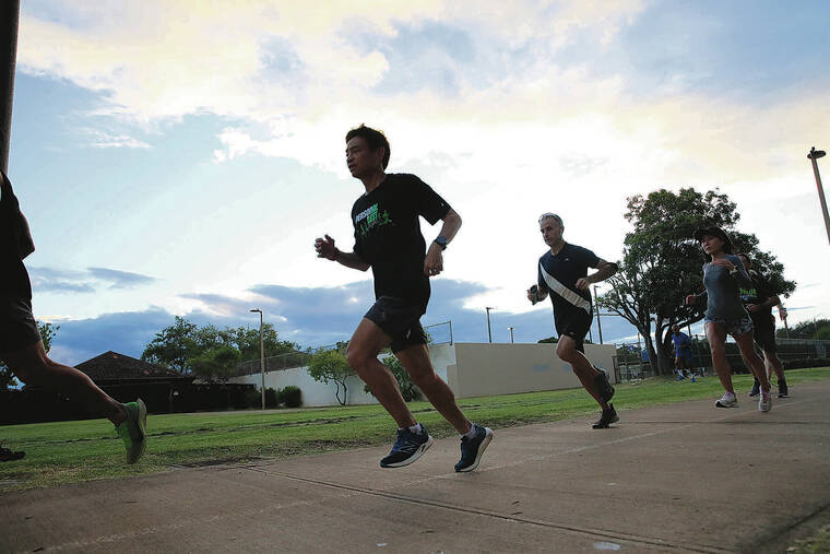 JAMM AQUINO / JAQUINO@STARADVERTISER.COM
                                Marathon runner Jonathan Lyau, middle, head coach of Personal Best Training, led runners during training at Ala Moana Regional Park on Nov. 2 in preparation for Sunday’s Honolulu Marathon. Lyau, who retired from running marathons, is giving it a go again. Marathon statisticians reported that there were 41 marathoners who accomplished the feat of breaking three hours in five decades.
                                ^^