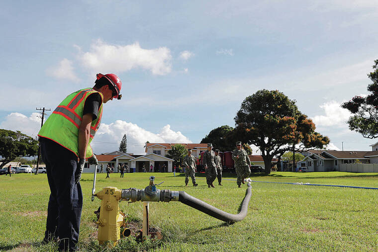JAMM AQUINO / JAQUINO@STARADVERTISER.COM
                                A Clean Harbors employee worked with a hydrant pumping groundwater into four large filtration units Monday as Navy personnel walked on-site at the Pearl City Peninsula military housing neighborhood. The Navy, working with contractors Aecom and Clean Harbors, started flushing waterlines at the housing, which could take 30-45 days to complete.