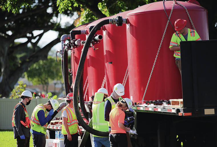 JAMM AQUINO / JAQUINO@STARADVERTISER.COM
                                Clean Harbors and Aecom employees Monday monitored the process of pumping groundwater into filtration tanks at the Pearl City Peninsula military housing neighborhood.